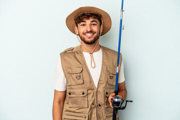 Fototapeta na wymiar Young mixed race fisherman holding a rod isolated on blue background happy, smiling and cheerful.