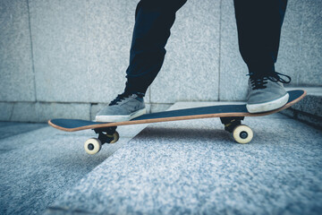 Fototapeta na wymiar Skateboarder riding skateboard goring down the stairs outdoors in city