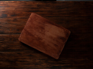 Tabla de madera rectangular vacía sobre mesa de madera. Empty rectangular wooden board on wooden table.