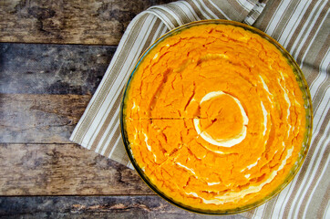 Pumpkin and cottage cheese casserole. round pumpkin diet pie, against a background of wooden table
