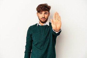 Young mixed race man isolated on grey background standing with outstretched hand showing stop sign, preventing you.