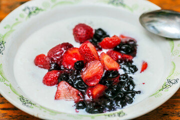 Berries with milk in plate