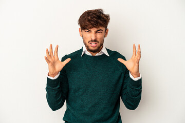 Young mixed race man isolated on grey background screaming with rage.