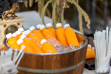 Orange juice bottle ice cold. Orange juice in plastic bottle in ice for sale in street food market. Orange juice bottles on the ice box