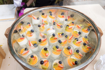 fruit salad topping on tofu. A cup of pudding fruit salad. Mix fruits salad topped on milk tofu in glass bowl.