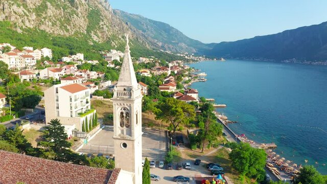 Tower St. Matthias Church in Dobrota town, Montenegro. Aerial drone view 4K.