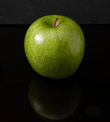 Manzana verde sobre fondo negro. Green apple on black background.