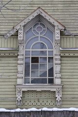 Ornamental window, carved frame. Ancient wooden house of merchant Sapozhnikov on Simanovsky Street,...