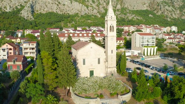 Around ofSt Matthew the Apostle Church in Dobrota town of Kotor Bay, Montenegro. Aerial drone view 4K.