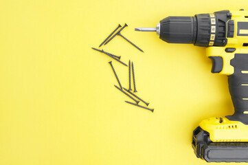 The yellow-black screwdriver on a yellow background, screws.