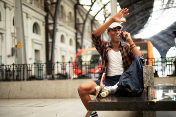 Obraz premium Happy young man waiting for the train. African man waiting in a subway. Man using a phone