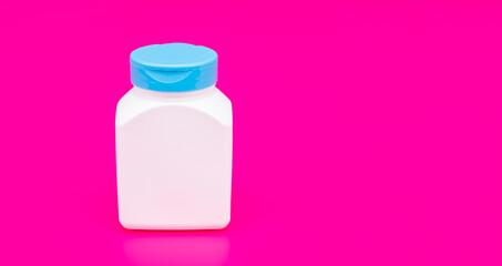 presenting vitamin product. white unbranded pill jar. multivitamin bottle on pink background.