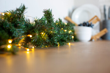 light bulbs in coniferous branches on kitchen table. christmas atmosphere.home decor for celebration