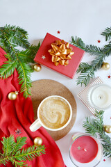 Cup of coffee with candles, gift box, fir tree branches, Christmas decorations on the white background. Merry Christmas mood. Cozy, comfort new year atmosphere. New year morning coffee. Place for text