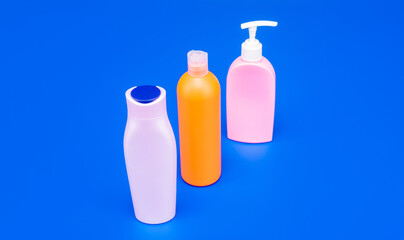 Refillable plastic toiletry packaging containers HDPE multicolor blue background copy space, bottles