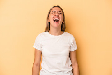 Young caucasian woman isolated on yellow background relaxed and happy laughing, neck stretched showing teeth.