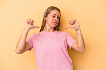 Young caucasian woman isolated on yellow background feels proud and self confident, example to follow.