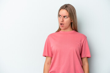 Fototapeta premium Young caucasian woman isolated on blue background being shocked because of something she has seen.