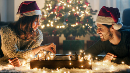 Coppia di ragazzo e ragazza giocano a scacchi nel periodo di Natale