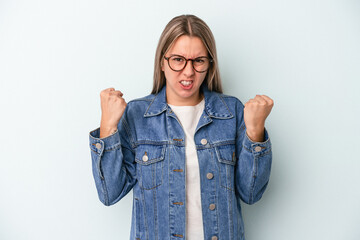 Young caucasian woman isolated on blue background upset screaming with tense hands.