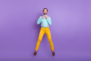 Full size photo of cool young brunet guy jump wear tie suspenders shirt pants shoes isolated on purple background