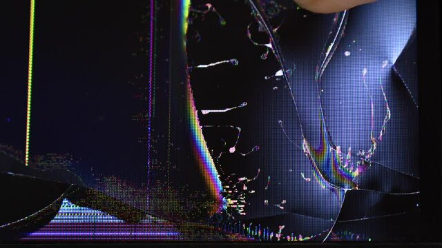 A man presses his finger on a broken TV or computer screen.