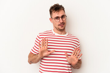 Young caucasian man isolated on white background rejecting someone showing a gesture of disgust.