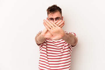 Young caucasian man isolated on white background doing a denial gesture