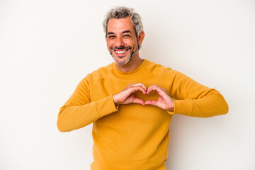 Middle age caucasian man isolated on white background  smiling and showing a heart shape with hands.