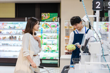 Obraz premium スーパーで食料品の買い物をする若い主婦