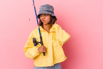 Young mixed race woman practicing fishing isolated on pink background touching back of head, thinking and making a choice.