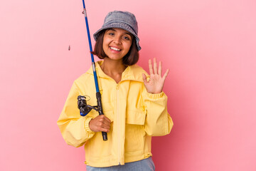 Young mixed race woman practicing fishing isolated on pink background smiling cheerful showing number five with fingers.