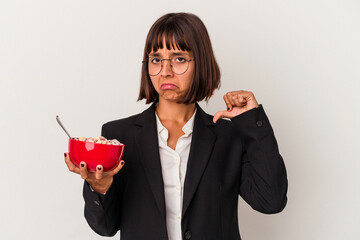Young mixed race business woman eating cereals isolated on white background feels proud and self...