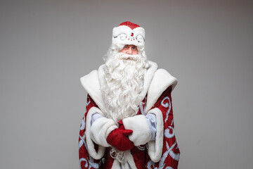 Santa Claus pointing by hand on empty space on gray studio background with copy space for xmas new year advertising