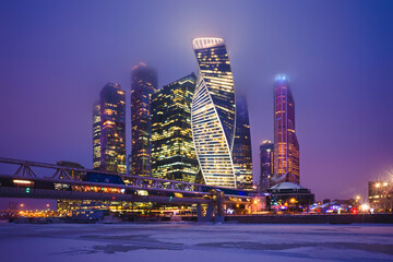 Skyscrapers in a business business center, financial district, evening, night sky, illuminated buildings, empty space, Bagration bridge, Moscow city, Moscow river, reflected in the water, Russia.