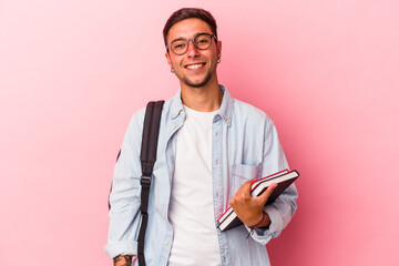 Young caucasian student man holding books isolated on pink background  happy, smiling and cheerful.
