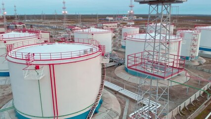 The drone flies around the oil storage tank, oil and gas reserves of Russia. Oil and gas industry in the world economy Oil field in Russia. Translation flammable no smoking