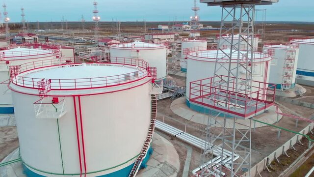 The drone flies around the oil storage tank, oil and gas reserves of Russia. Oil and gas industry in the world economy Oil field in Russia. Translation flammable no smoking