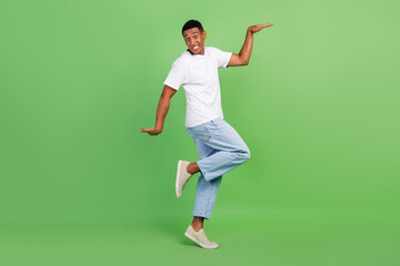Fototapeta na wymiar Full body profile side photo of young cheerful afro guy have fun dance walk isolated over green color background