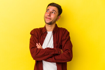 Young caucasian man with tattoos isolated on yellow background  dreaming of achieving goals and...