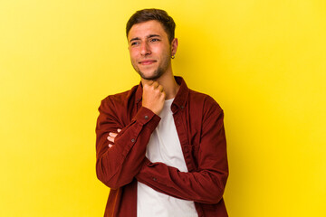 Young caucasian man with tattoos isolated on yellow background  suffers pain in throat due a virus or infection.