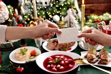 Sharing with Christmas Eve wafer at the festive table - obrazy, fototapety, plakaty