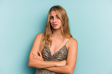 Young caucasian blonde woman isolated on blue background  unhappy looking in camera with sarcastic expression.