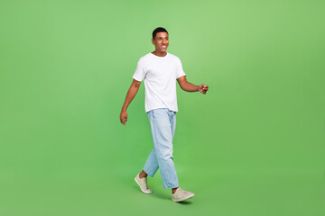 Full length profile side photo of young handsome african guy go walk isolated over green color background