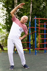 Elderly man doing fitness exercises outdoors