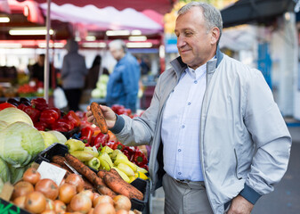 Man choosing carrots in market