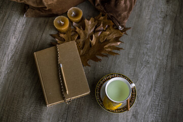 Cup of tea and old book resting on a rustic wooden table. Concept of break, leisure. Copy space