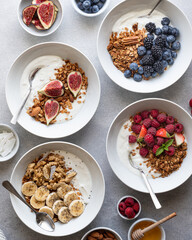 Granola with yogurt, berries, fruits and nuts on a concrete background, top view 