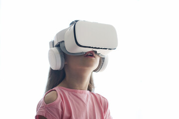 The girl is having fun in virtual reality glasses, standing on a white background. Copy space. High...