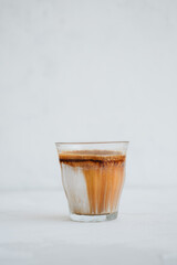 A glass of dirty coffee at white background